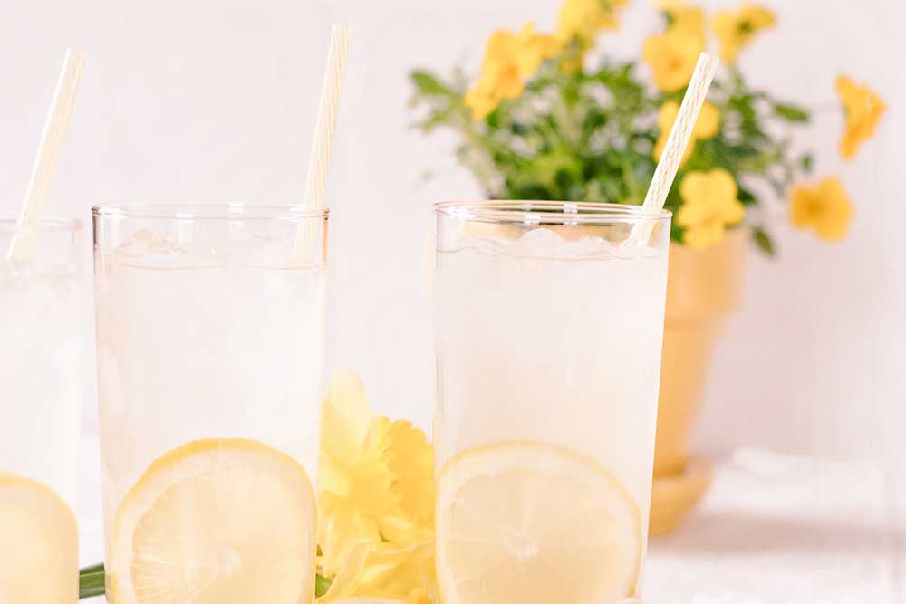 tall glasses of lemonade with yellow flowers in the background