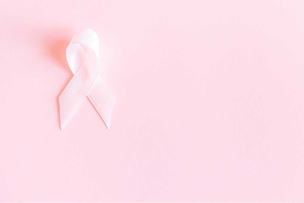 pink breast cancer ribbon against pink background
