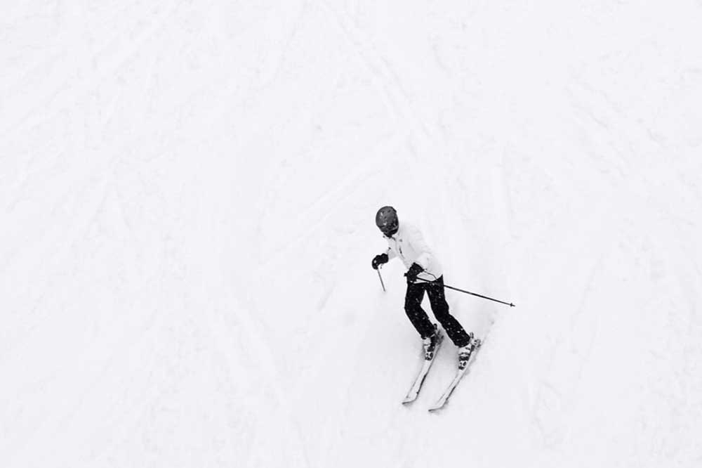 full body view of person skiing down a mountain of snow