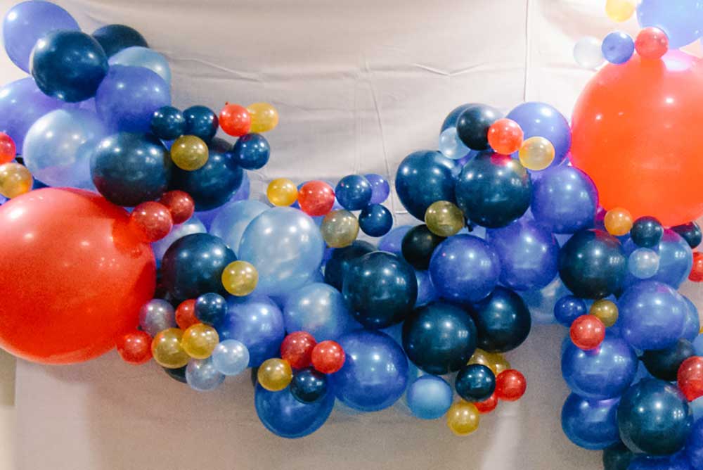 wall of different size balloons blue red and yellow
