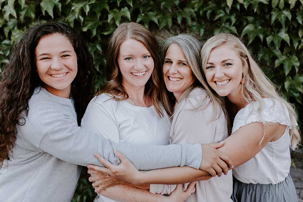 women smiling and hugging for a photo