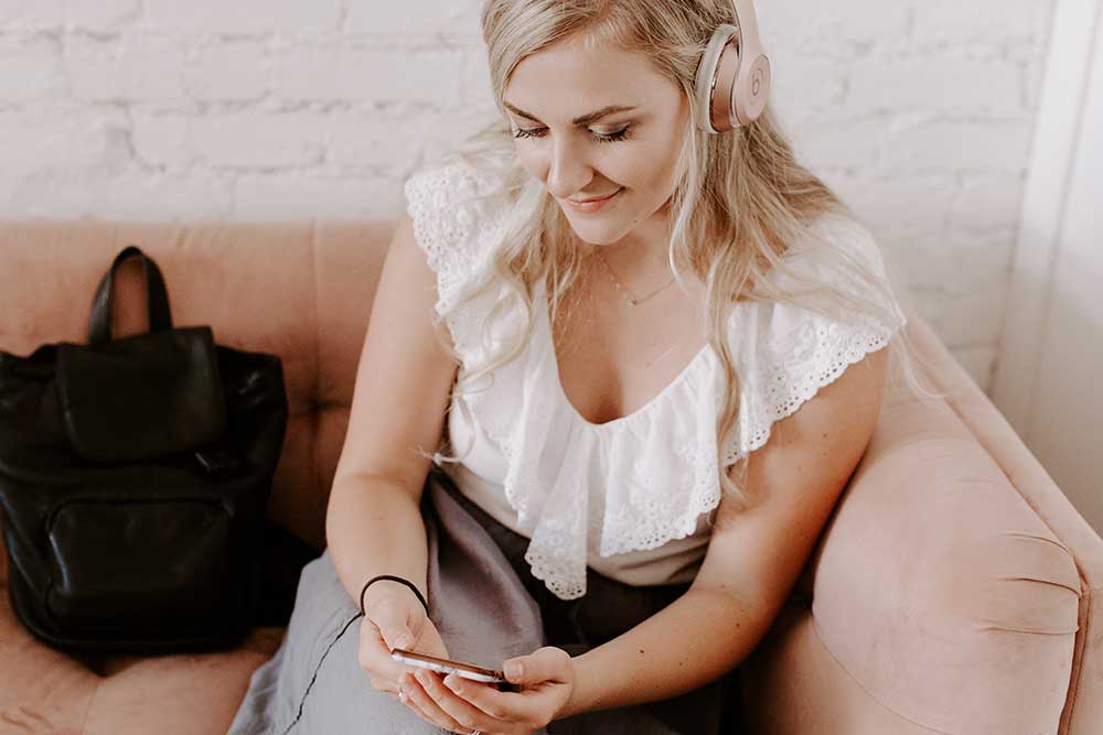 girl wearing headphones sitting on a couch