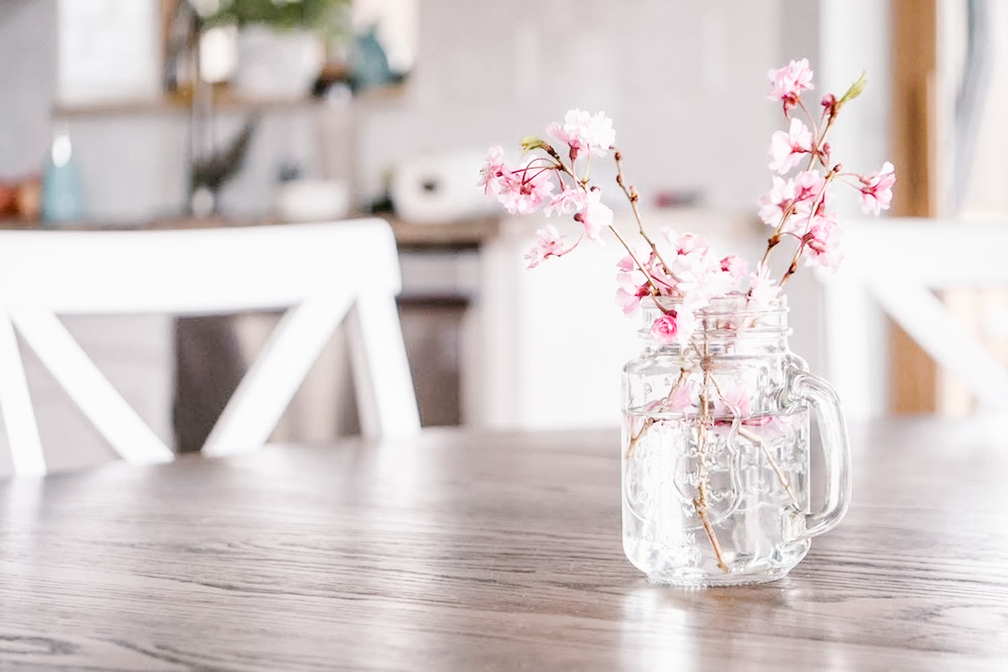 pink flowers in a jar on a table