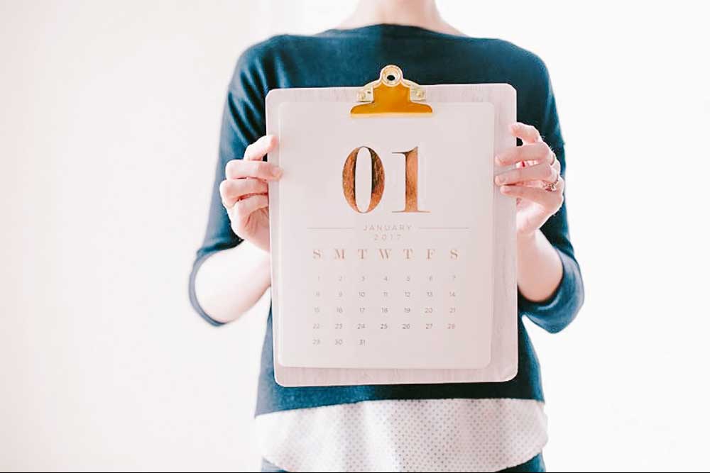 Collide blog woman holding her resolutions calendar on a clipboard