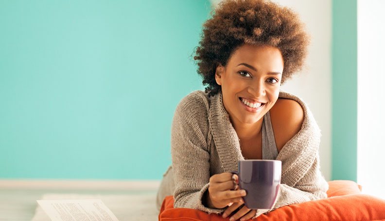 smiling woman of color with coffee mug