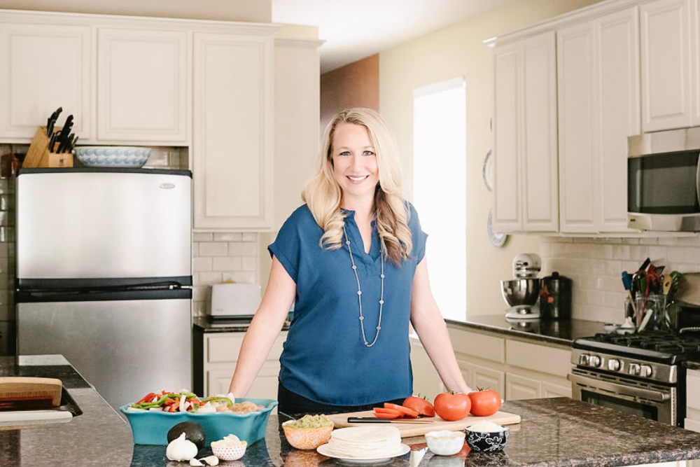 woman smiling and standing in kitchen