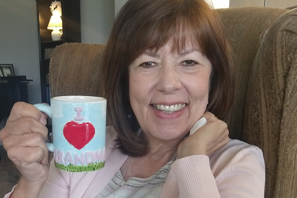 woman smiling with grandma mug in hand