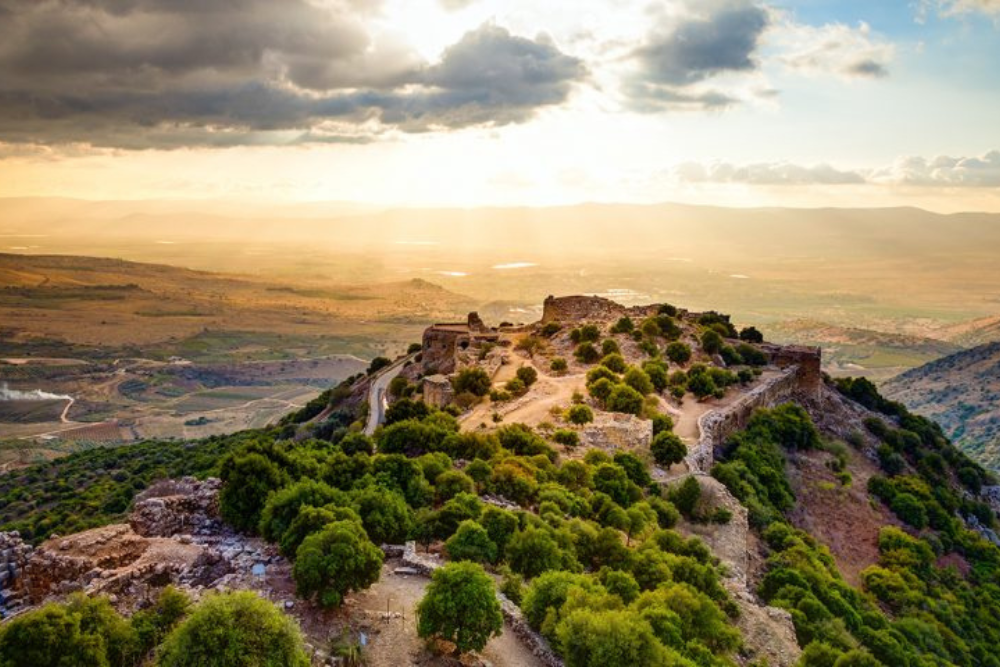 Mountain with trees and ancient buildings overlooking Israel valley