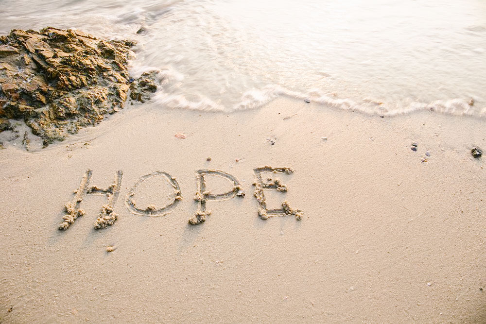 hope written in sand on a beach
