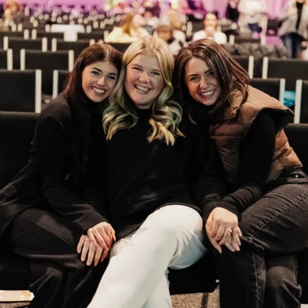 Women sitting together and smiling at Collide Conference.